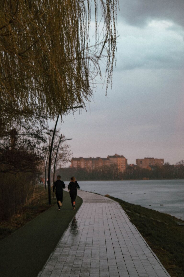 Két futó a folyóparti sétányon szürkületben