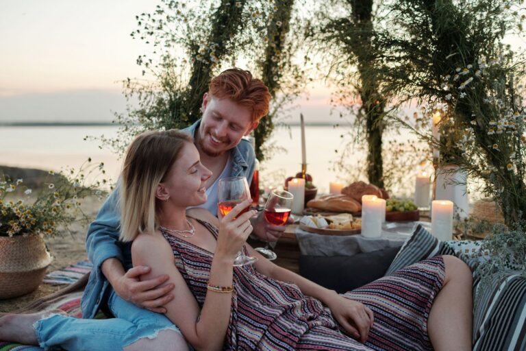 Pár borozik gyertyafényes nyáresti teraszon naplementében