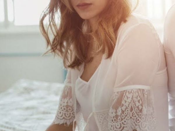 Nő az ágyon elgondolkodva - miért fájhat a szex